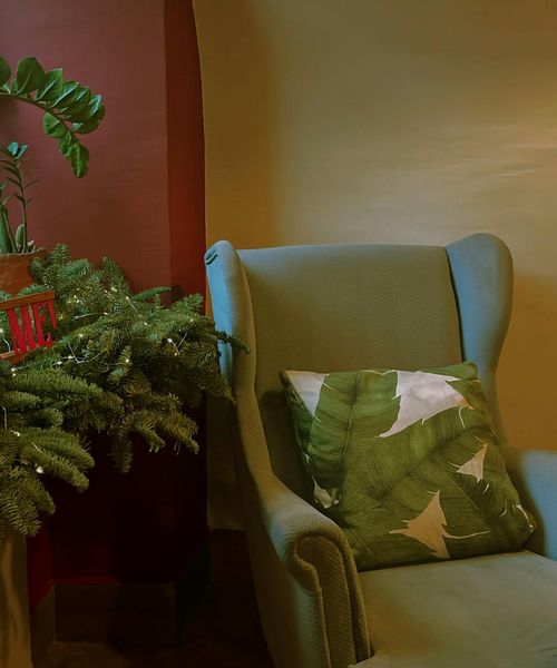 A cozy corner of a room with a yoga mat, a plant, and soft lighting.