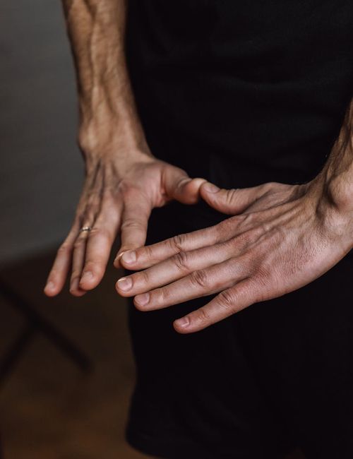 Close-up of a person's hands in a meditative mudra gesture.